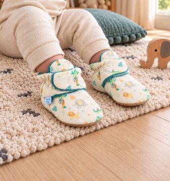Baby boy wearing Dotty Fish Cotton Booties in safari design