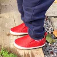 Toddler wearing red rubber sole shoes outside