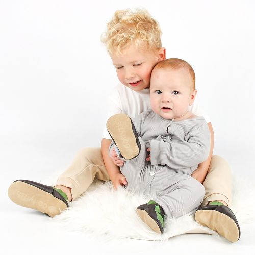Toddler and his baby brother wearing Jurassic Jake dinosaur soft sole leather slippers by Dotty Fish 