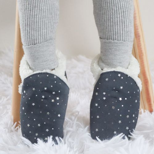 Child wearing warm fleece lined grey suede slippers with silver stars from Dotty Fish 