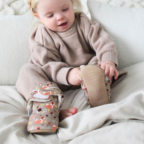 Toddler wearing cotton booties with woodland pattern.