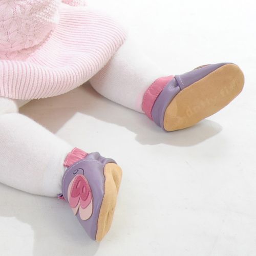 Baby girl sitting wearing purple Dotty Fish barefoot shoes with pink ankle trim and pink butterfly design.