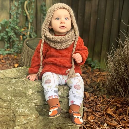 Baby wearing Dotty Fish Freddie Fox soft leather baby shoes while sitting outside in autumn leaves