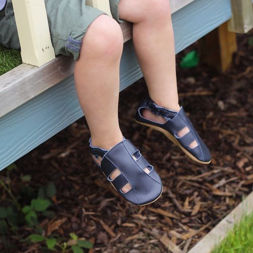 Toddler wearing Dotty Fish Navy sandals while outside playing 