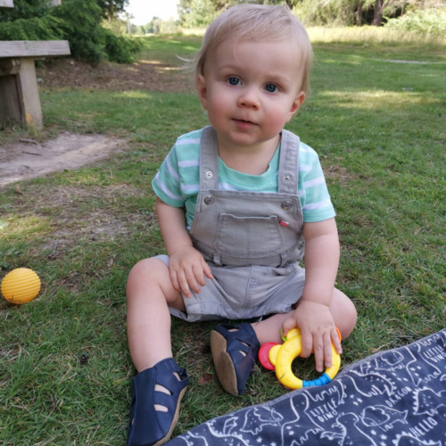 Baby boy wearing navy blue soft leather sandals from Dotty Fish while playing outside