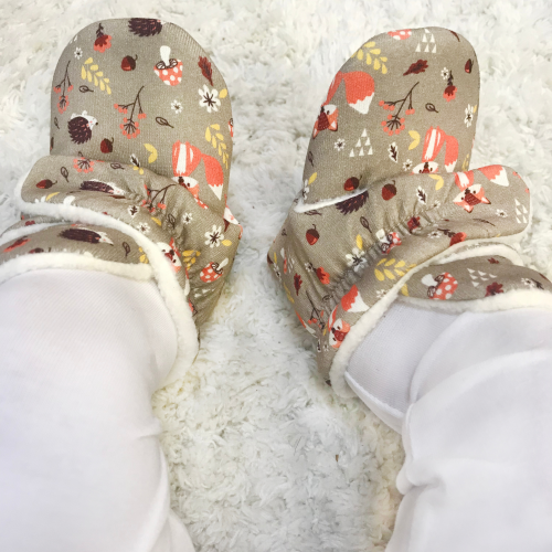 Baby wearing warm cotton baby booties with woodland animal design from Dotty Fish 