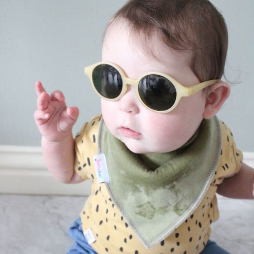 Baby wearing Dotty Fish olive green cotton bandana bib and sunglasses.