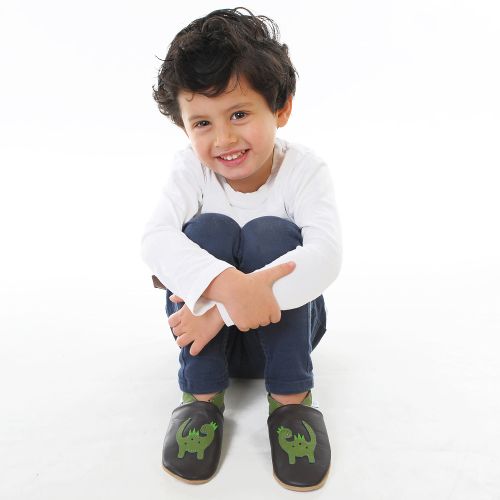 Little boy wearing soft leather indoor slippers with green dinosaur motif from Dotty Fish 