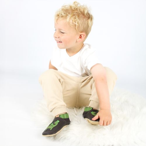Small boy wearing soft leather indoor slippers with green dinosaur motif from Dotty Fish 
