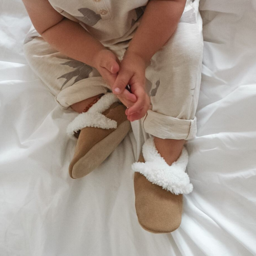 Toddler wearing fleece lined tan suede slippers by Dotty Fish 