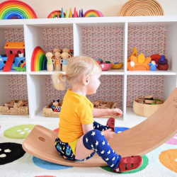 Toddler playing in colourful playroom wearing bright red leather sandals from Dotty Fish