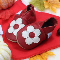 Ruby red soft leather baby girls shoes pictured with a red cotton baby bib from Dotty Fish 