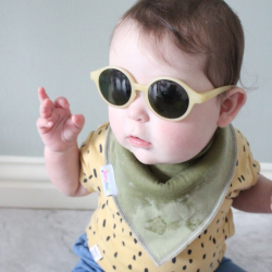 Young baby wearing Olive Green Baby Bib while teething