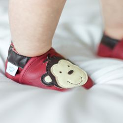 Baby standing wearing red leather cheeky monkey baby shoes by Dotty Fish