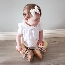 Little girl wearing warm cotton baby booties with woodland animal design from Dotty Fish 