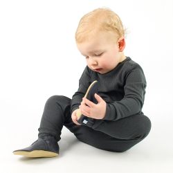 Toddler boy sitting on floor wearing navy blue leather Dotty Fish first walker shoes.