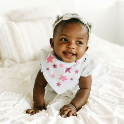 Baby girl wearing Dotty Fish white cotton bandana bib with pink stars pattern.