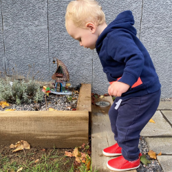 Little boy wearing Dotty Fish red leather pre-walker rubber sole slip-on shoes.