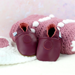 Dotty Fish plum soft leather baby shoes pictured with knitted baby blanket