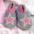 Grey and pink leather shoes in drawer with baby clothing.
