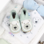 Dotty Fish icy blue leather soft sole unisex infant shoes with white polar bear design, sitting in drawer.