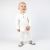 Infant boy standing, wearing grey Dotty Fish barefoot shoes with white and grey stripe elephant design.