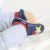 Baby wearing blue Dotty Fish soft sole infant shoes with multicoloured fish design.