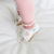 Baby wearing white leather Dotty Fish first walker barefoot shoes with pink hearts.