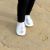 Little girl on beach wearing Dotty Fish silver leather pre-walker rubber sole slip-on shoes.