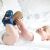 Baby wearing navy cotton booties, with dinosaur design.