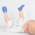 Baby boy lying down, wearing blue leather Dotty Fish first walker barefoot sandals.