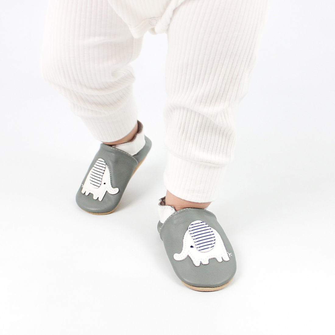 Baby taking first steps wearing Dotty Fish soft leather baby shoes with elephant motif