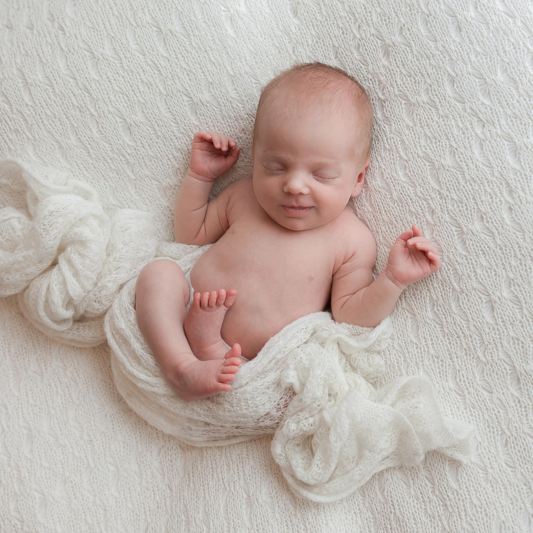 Newborn baby with white blanket.
