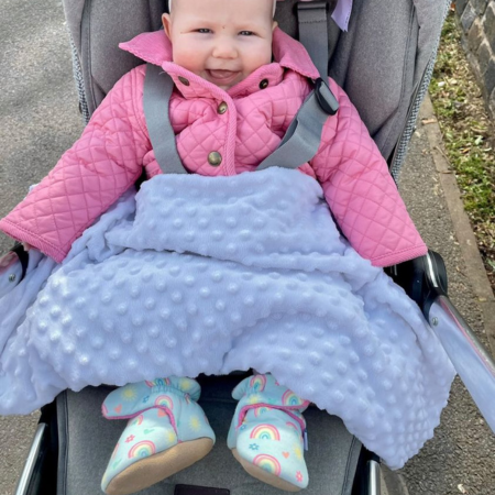 Baby wearing Dotty Fish booties while out in her buggy