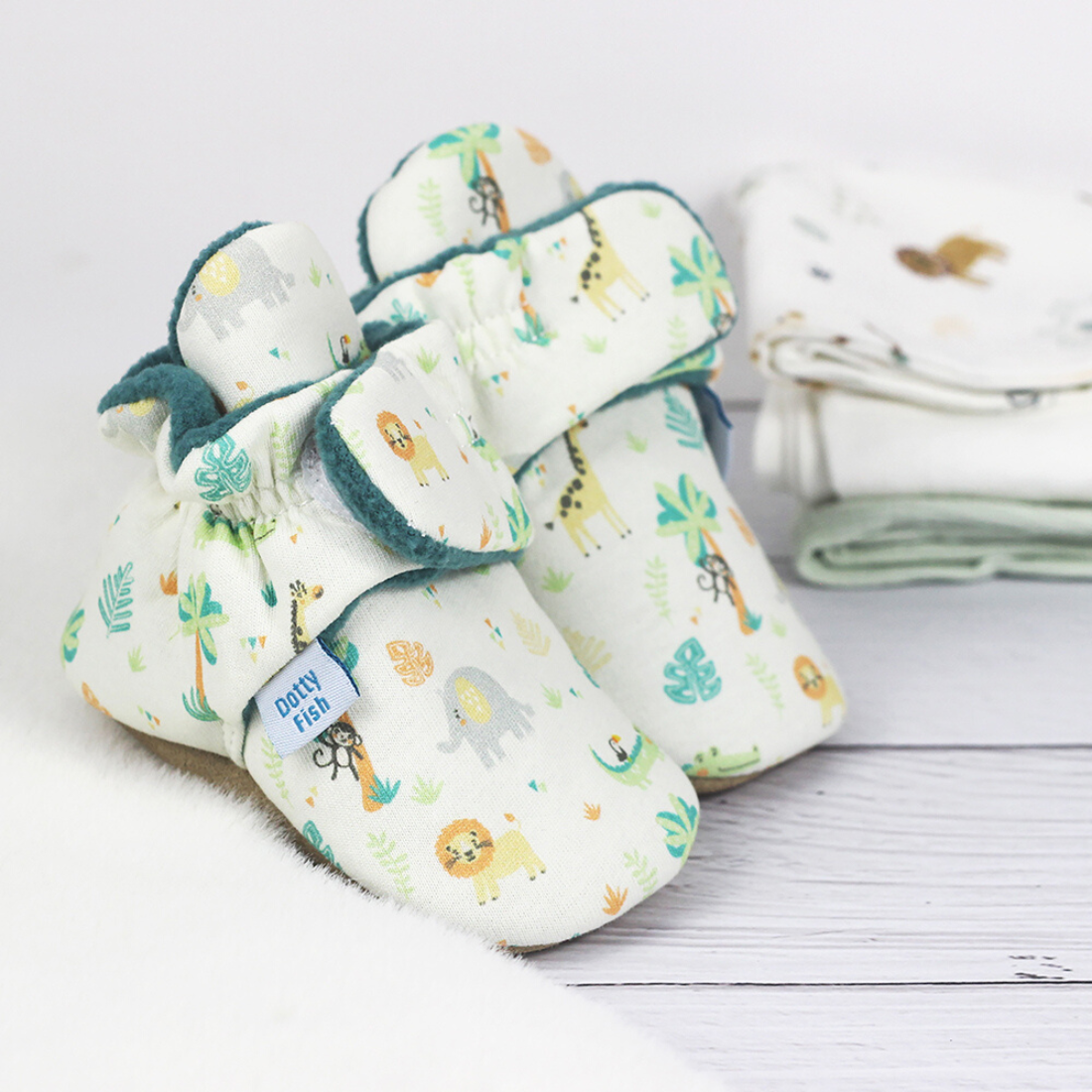 Baby booties with elasticated ankles and adjustable strap