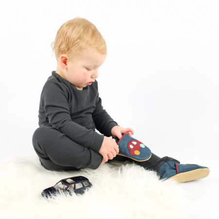Young child learning to put shoes on