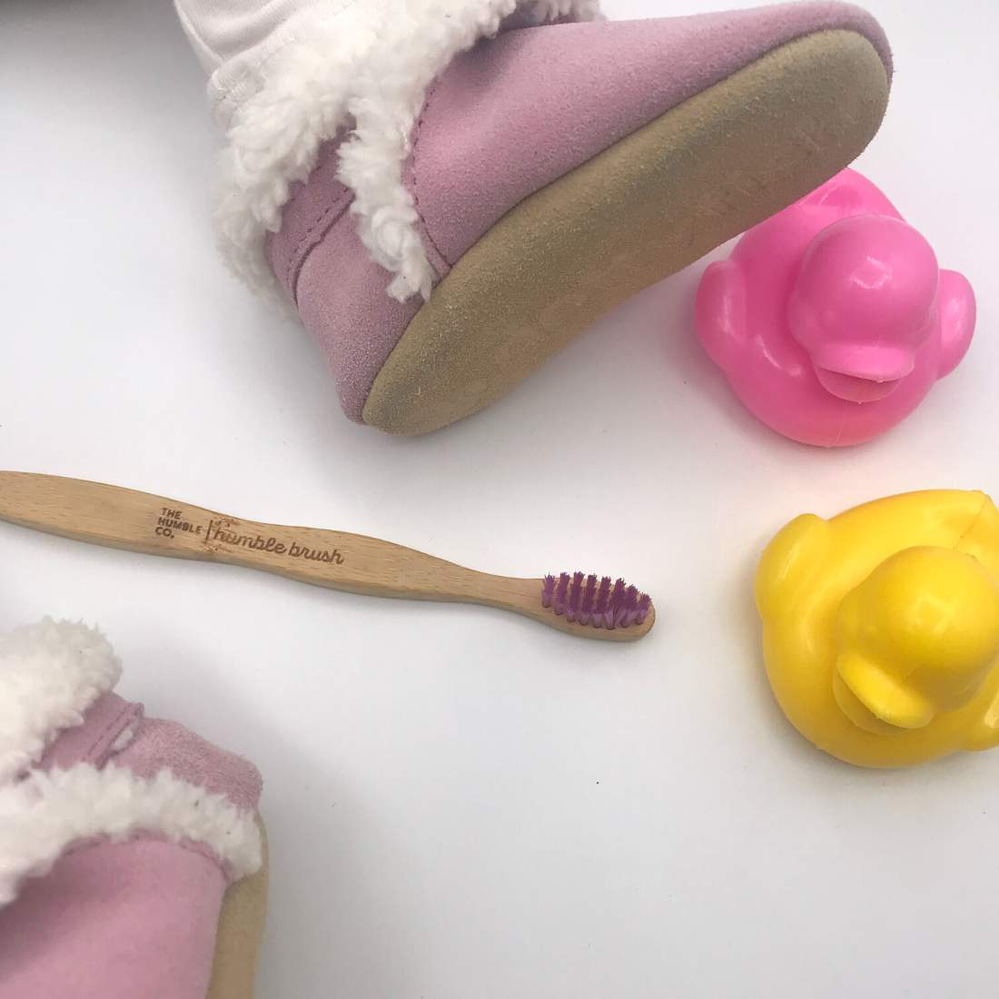 Baby wearing suede slippers having teeth brushed